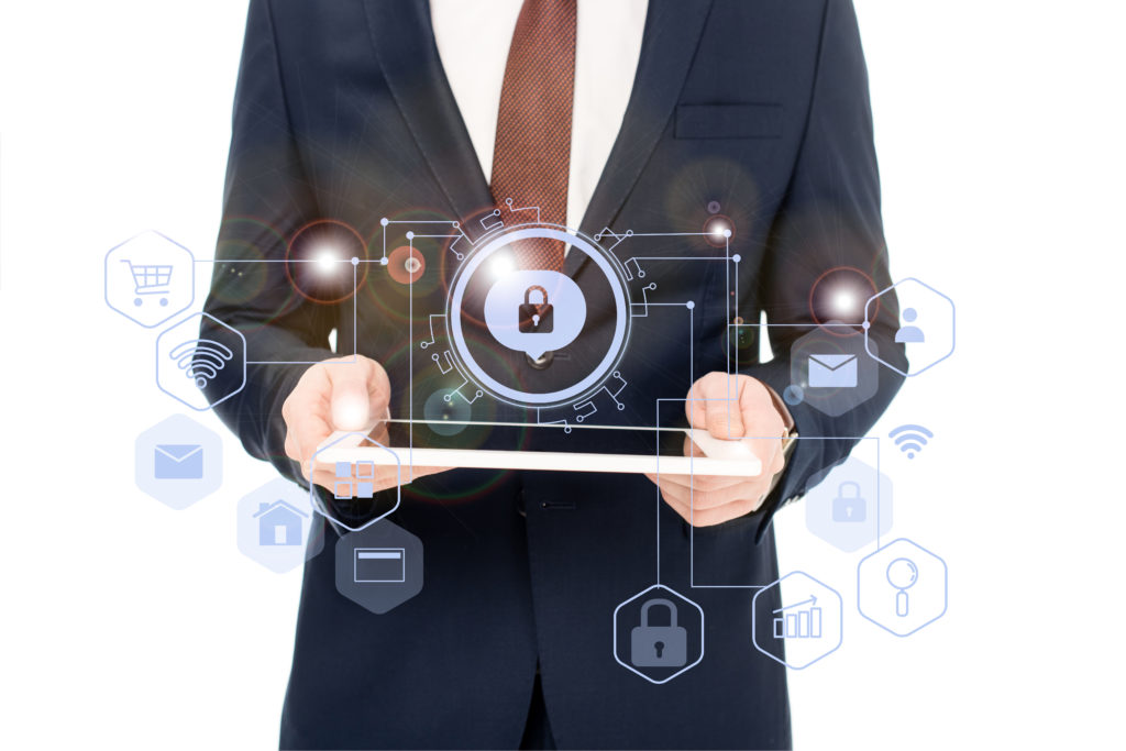 A man stands holding a tablet with icons of a lock, money, internet, data, and more to signify network security